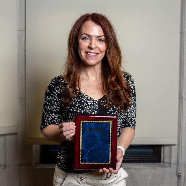 Dr. Cecret Tacker poses with her award