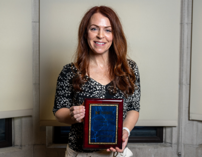 Dr. Cecret Tacker poses with her award