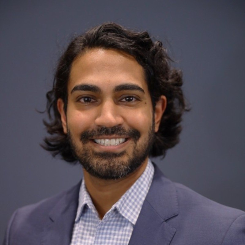 Man in a suit smiles for a headshot