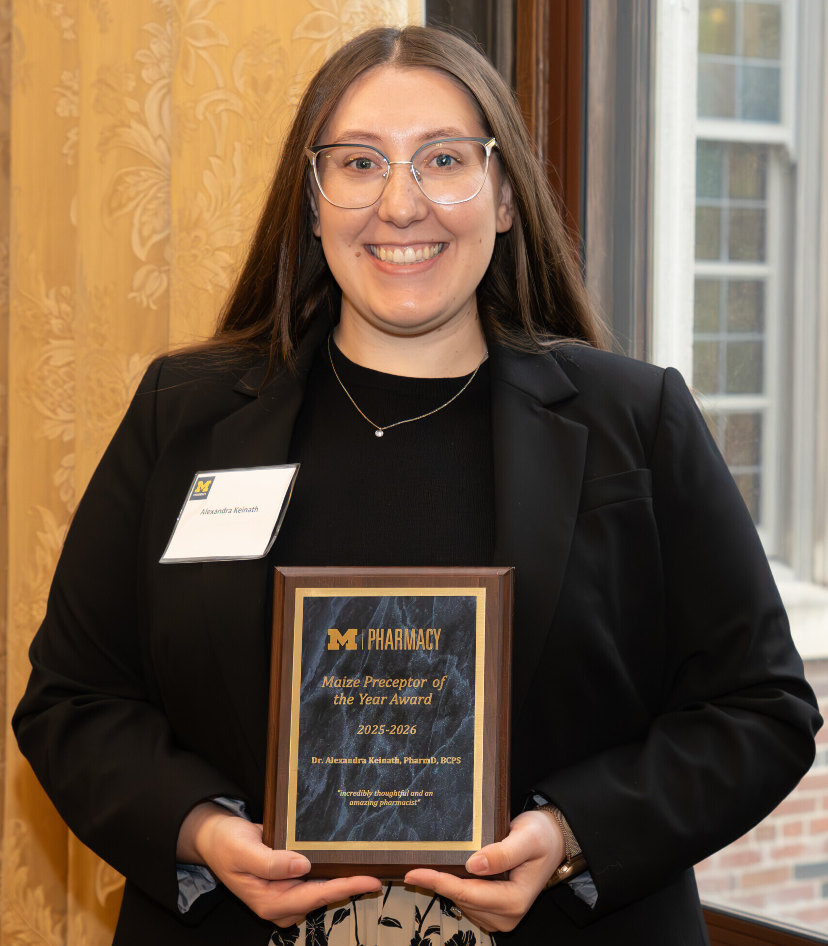Dr. Alexandra Keinath is smiling with the Maize Preceptor of the Year Award.
