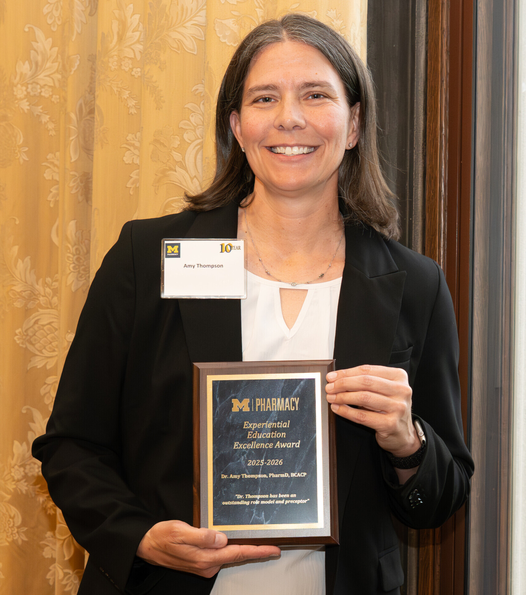 Dr. Amy Thompson is smiling with the Experiential Education Excellence Faculty Award.