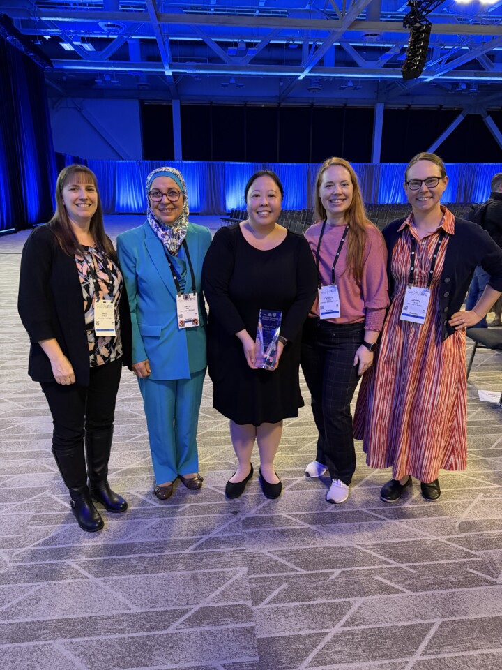 Dr Hanna Phan and colleagues smiling. Dr Phan holding an award