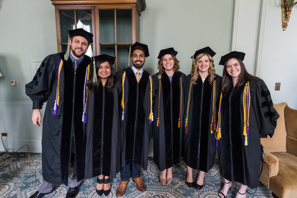 Group of pharmacy students pose for a photo at graduation. 