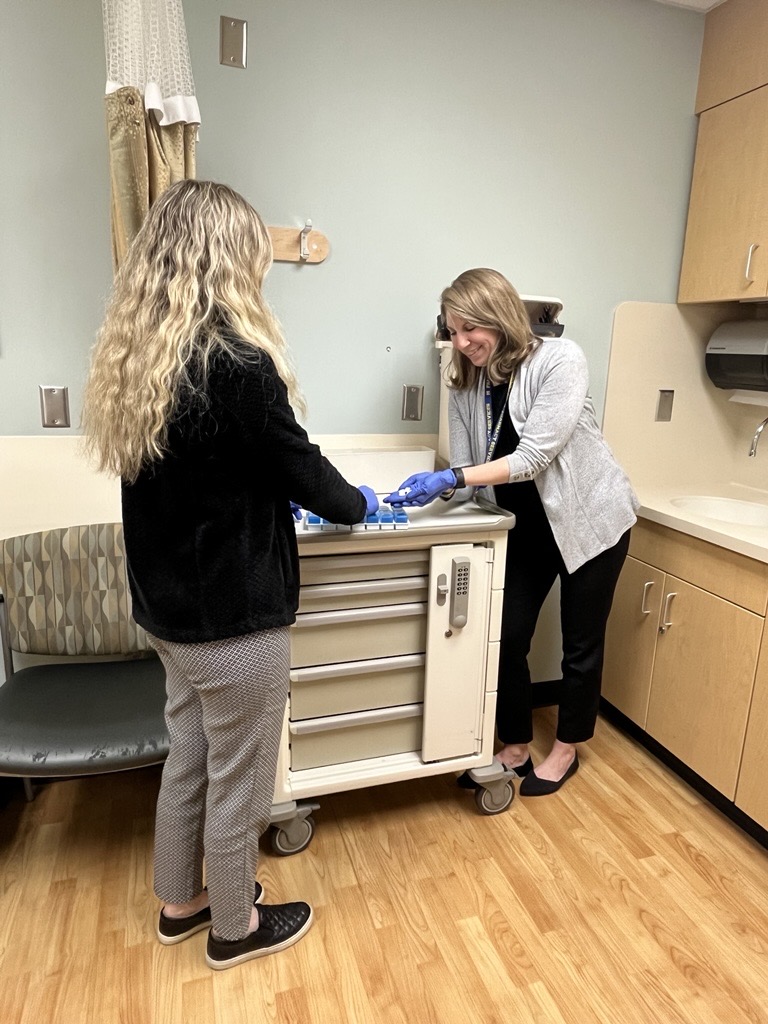 Jennifer Hagopian working with a preceptor. Both are looking at a pill container.