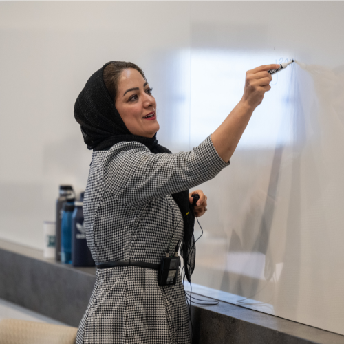 Professor writing on a whiteboard