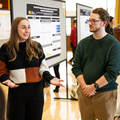 student presenting their research poster